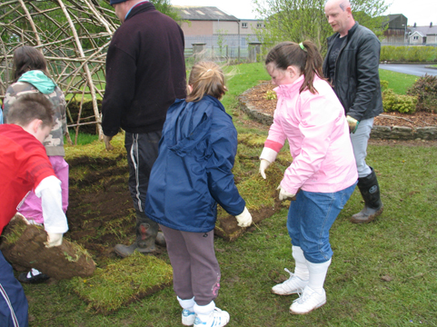 Building a Mesolithic hut. St Malachy's pupils start to build up the walls.